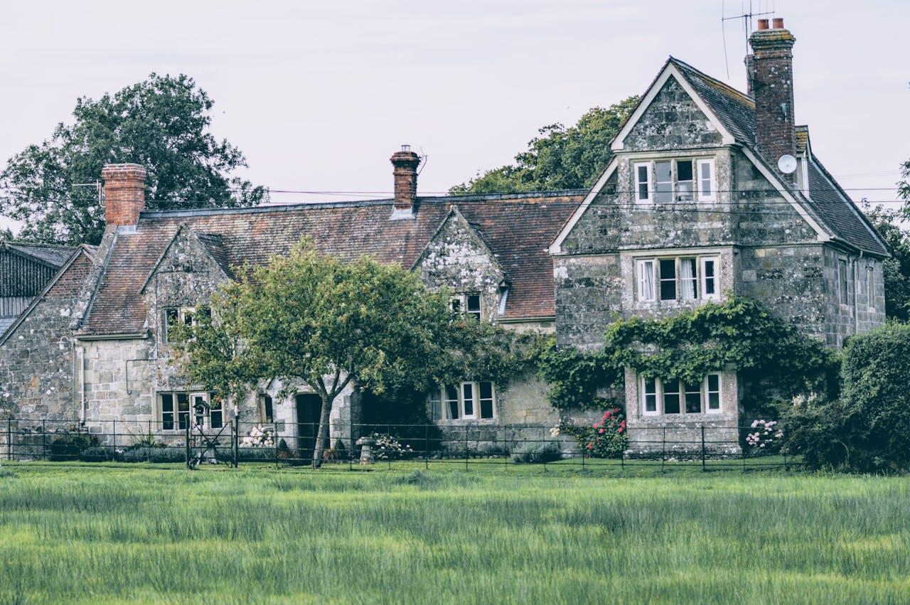 Picturesque old stone house in rural countryside with lush greenery, perfect for serene nature retreats.
